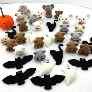 May include: A collection of Halloween-themed miniature figurines, including brown, gray, and white teddy bears with red bowties, black bats, black cats, and white ghosts with mustaches. An orange pumpkin is also present.