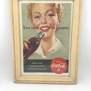 Reklama Coca-Coli z 1951 r. „Poczuj jej jakość” Reklama w czasopiśmie oprawiona w ramę