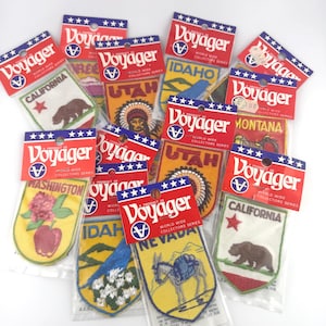 May include: A collection of vintage Voyager World Wide Collectors Series patches. Each patch features a state design, including California, Idaho, Utah, Montana, Washington, and Nevada. The patches are in their original packaging.
