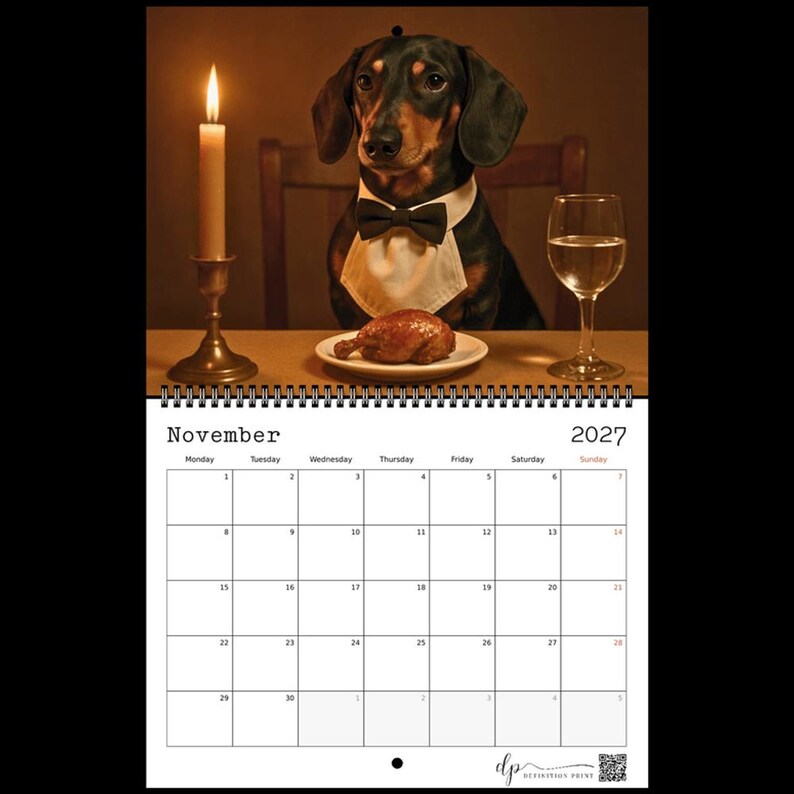 May include: A 2027 wall calendar for November featuring a black and tan dachshund wearing a white bib and black bow tie, sitting at a table with a lit candle, a glass of water, and a cooked piece of poultry on a white plate in front of it.