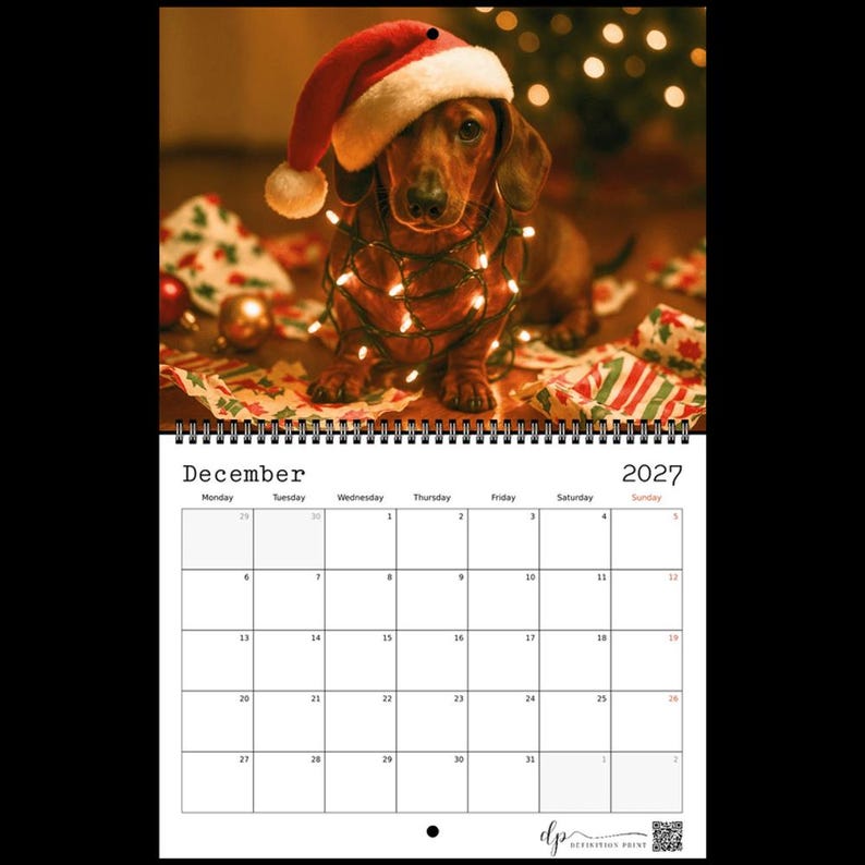 May include: A wall calendar for December 2027 featuring a brown dachshund wearing a red and white Santa hat, wrapped in glowing string lights. The calendar grid displays the month, year, and days of the week with a white background and black text.