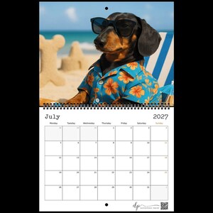 May include: A 2027 wall calendar for the month of July featuring a photograph of a dachshund wearing black sunglasses and a blue shirt with an orange floral pattern. The dog is positioned on a beach with sand structures in the background.