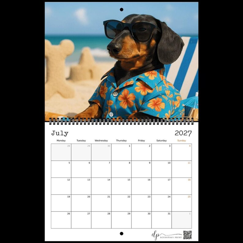 May include: A 2027 wall calendar for the month of July featuring a photograph of a dachshund wearing black sunglasses and a blue shirt with an orange floral pattern. The dog is positioned on a beach with sand structures in the background.