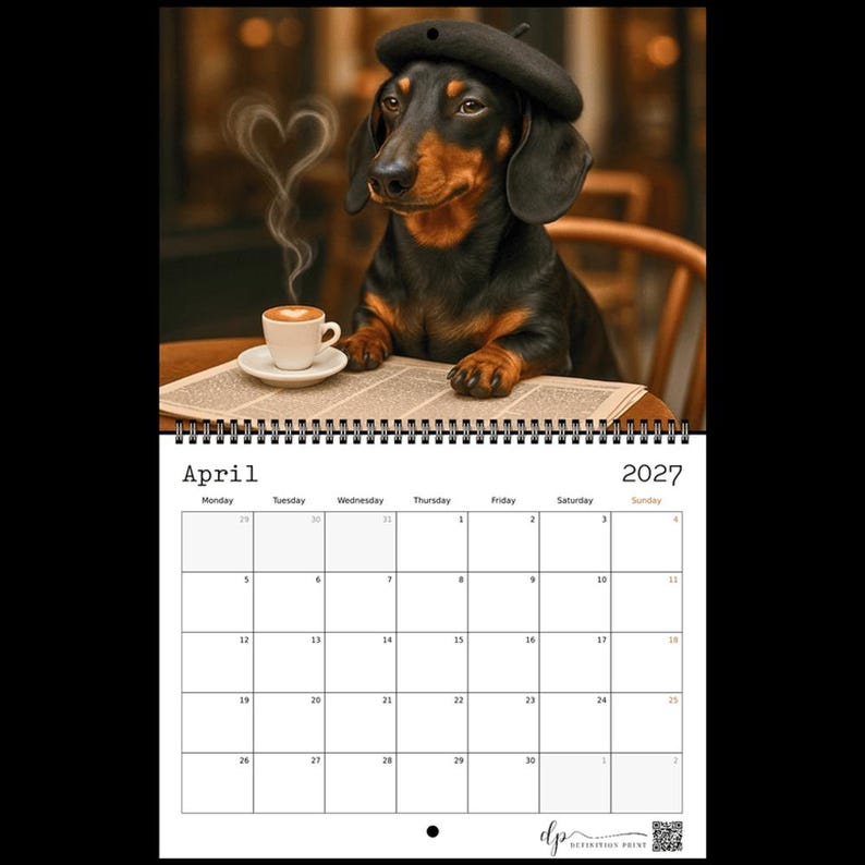 May include: A 2027 wall calendar for April featuring a black and tan dachshund wearing a dark beret. The dog sits at a table with a white coffee cup emitting heart-shaped steam next to a newspaper. The calendar grid shows dates for the month.