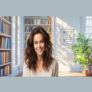 May include: A woman with long brown hair smiles at the camera. She is wearing a light beige sweater. Behind her are bookshelves filled with books and a framed print with the text "As for me and my house, we will serve the Lord."