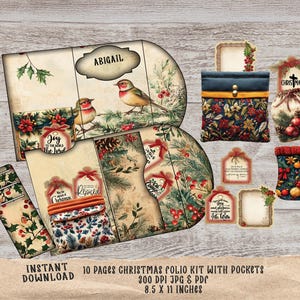 May include: A Christmas folio kit with pockets, featuring illustrations of birds, holly, and festive tags. The kit includes a pouch, a stocking, and decorative tags. The text "Joy to the World" and "Rejoice" are visible. The kit measures 21.6 x 27.9 cm.