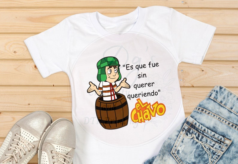Może przedstawiać: Biała koszulka z kresk&oacute;wkową postacią El Chavo del Ocho, popularnej meksykańskiej postaci telewizyjnej, siedzącej w beczce. Na koszulce nadrukowany jest tekst "Es que fue sin querer queriendo".