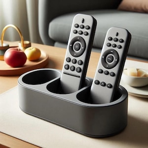 May include: A gray remote control holder with three slots for remotes. Two gray remotes are in the holder. The holder is on a wooden table.