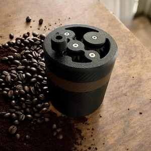 May include: A black and brown coffee grinder with a visible grinding mechanism. The grinder is surrounded by coffee beans and grounds.
