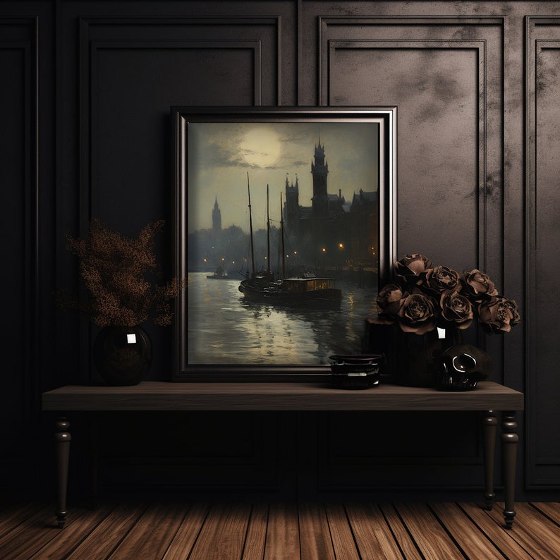 Puede incluir: Una pintura enmarcada de una ciudad nocturna con luna llena en el cielo. La pintura est&aacute; en un marco de madera oscura y est&aacute; colgada en una pared negra. Hay dos jarrones con flores en una mesa frente a la pintura.