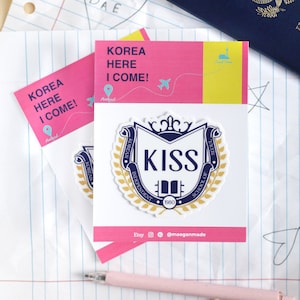 Peut inclure: Un autocollant représentant un blason avec les mots "KOREAN INDEPENDENT SCHOOL OF SEOUL" et "KISS" en lettres bleues. Le blason est entouré d'une couronne de laurier dorée et l'année "1980" est imprimée sous le blason.