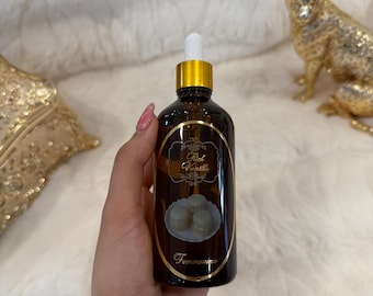 May include: A brown glass bottle with a gold cap and a white dropper. The label reads "Rich Vanilla" and features an illustration of macarons. The bottle is held against a soft, white background.