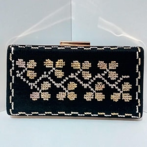 Può includere: Una pochette nera con chiusura dorata e un motivo floreale ricamato in filo oro e argento.