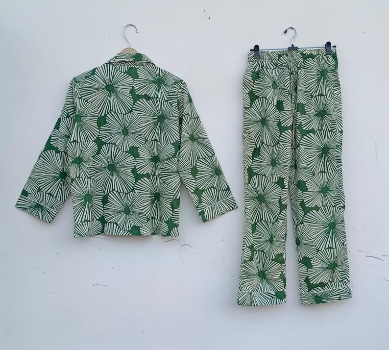 K&ouml;nnte beinhalten: Ein gr&uuml;nes und wei&szlig;es Pyjama-Set mit Blumenmuster. Das Oberteil hat einen Knopfleisten vorne und lange &Auml;rmel. Die Hose hat einen elastischen Bund.