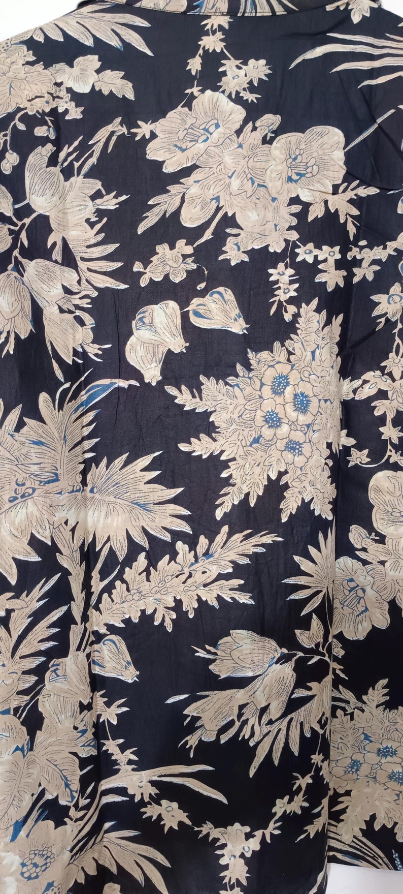 May include: Black fabric with a white floral pattern. The fabric has a soft, flowing texture and is perfect for creating garments or home decor.