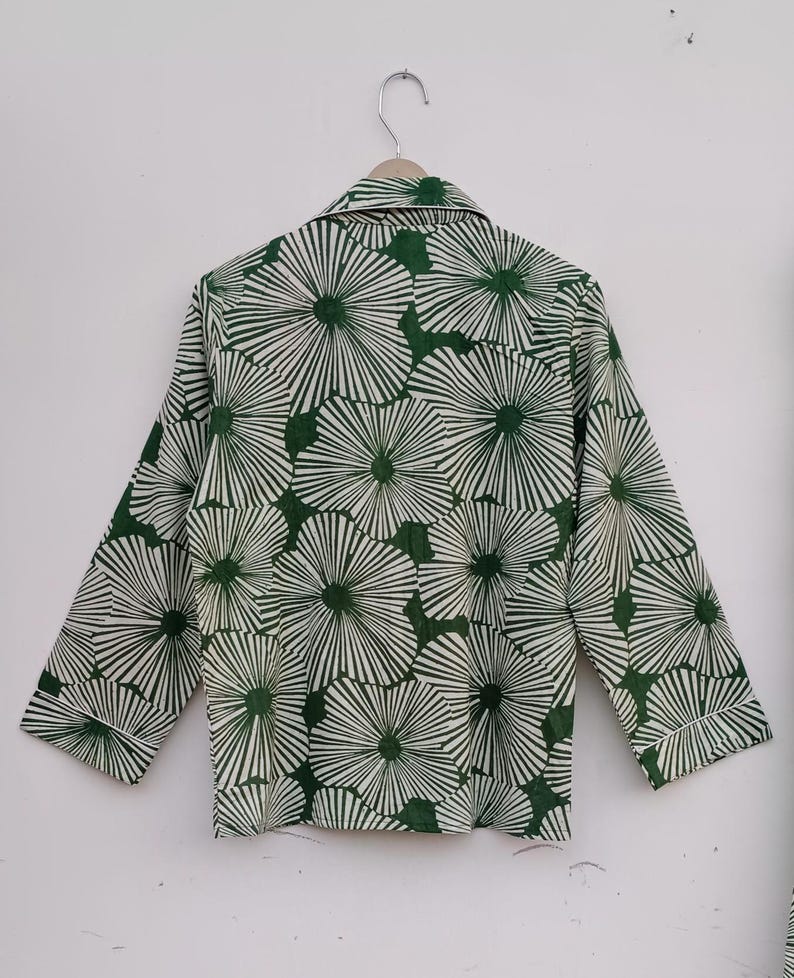 K&ouml;nnte beinhalten: Ein lang&auml;rmliges Hemd in Gr&uuml;n und Wei&szlig; mit einem floralen Muster. Das Hemd hat einen Knopfkrag und eine lockere Passform.