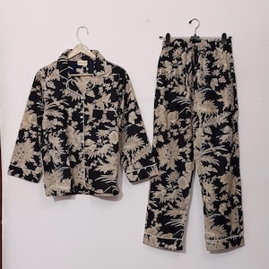 May include: A black and cream floral print pajama set with a long-sleeved button-up shirt and matching pants.