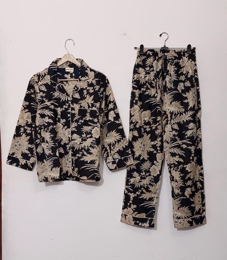 May include: A black and cream floral print pajama set with a long-sleeved button-up shirt and matching pants.