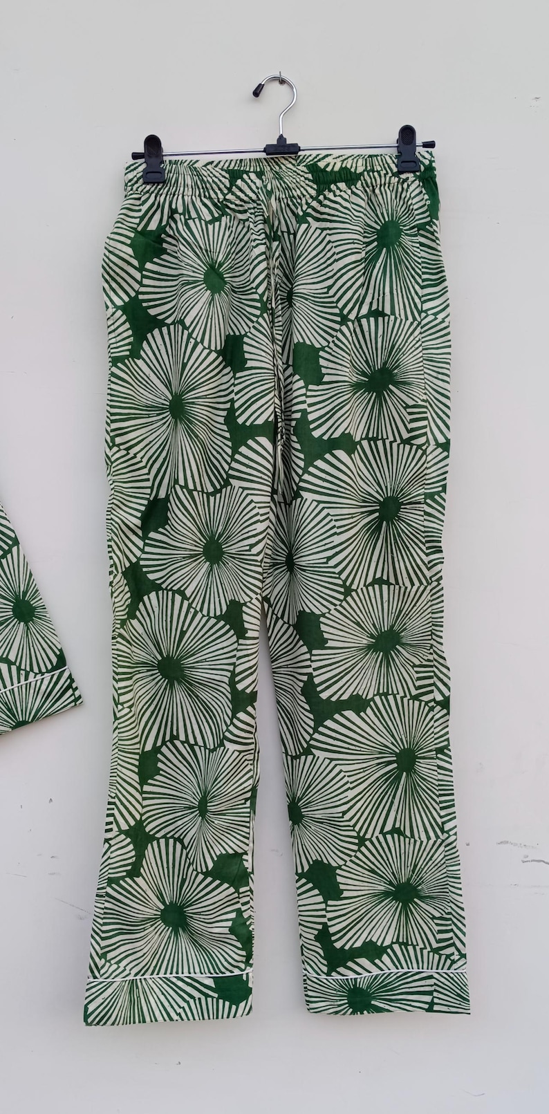 K&ouml;nnte beinhalten: Gr&uuml;n-wei&szlig;e gemusterte Hose mit Blumenmuster. Die Hose hat einen Kordelzugbund und eine lockere Passform.