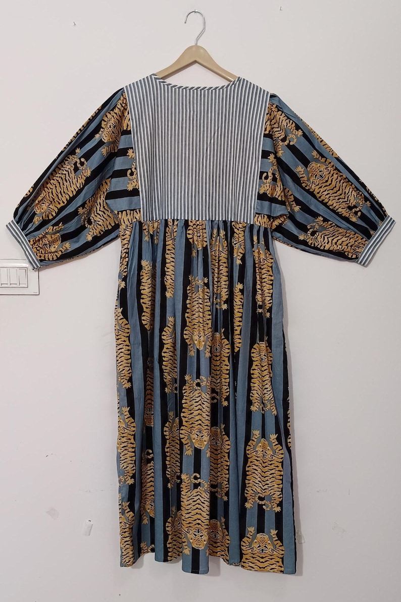 May include: A blue and black striped dress with a tiger print. The dress has a gathered skirt and 3/4 sleeves.