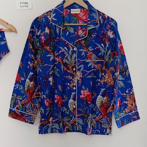 May include: Blue pajama set with a vibrant floral and bird print. The long-sleeved top has white piping and buttons. The text "FUTURE TEXTILE" is visible on a tag.
