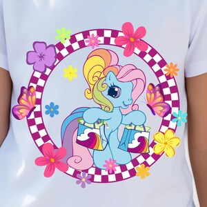 May include: A colorful cartoon pony with a rainbow mane and tail is holding two shopping bags. The pony is surrounded by flowers and butterflies in a checkered circle.