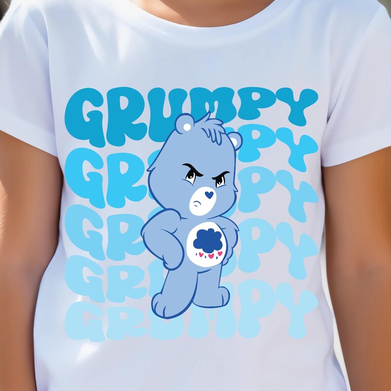 May include: White t-shirt with a blue Care Bear character wearing a blue cloud with pink hearts. The text "GRUMPY" is repeated in a blue gradient on the shirt.