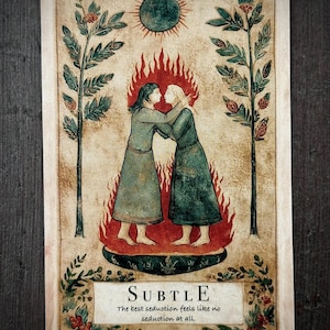 May include: A rectangular card featuring an illustration of two figures in long robes standing in flames, embracing. Above them is a dark sun, flanked by two trees. At the bottom, a label reads: SUBTLE. The best seduction feels like no seduction at all.