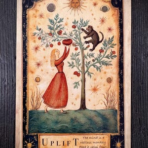 Può includere: Carta illustrata con una donna in abito rosso e una scimmia che raccoglie frutta da un albero. La carta ha un bordo con elementi celesti e la parola "UPLIFT". Il testo recita: "La mente è una scimmia irrequieta. Nutritela con frutta calma."