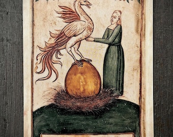 May include: A rectangular card featuring a medieval-style illustration of a person in a green dress standing beside a large golden egg in a nest, with a mythical bird perched on top. The text HATCH and The unseen work is the only work that lasts.