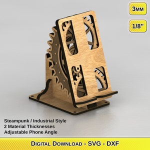 May include: A wooden phone stand in a steampunk/industrial style. The stand features a gear design and adjustable phone angle. The material thickness is 1/8 inch (3mm). The text on the image says "DIGITAL DOWNLOAD - SVG - DXF".