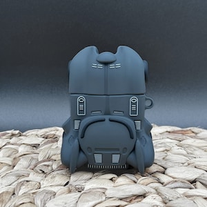 May include: A black silicone phone case shaped like the Batmobile from the Batman franchise.