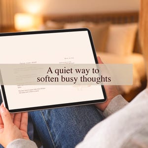 Könnte beinhalten: Ein Tablet-Bildschirm mit dem Text "A quiet way to soften busy thoughts". Der Bildschirm zeigt auch die Sätze "Onist your mind" und "How to use". Das Tablet wird auf dem Schoß einer Person gehalten, mit einem unscharfen Hintergrund.