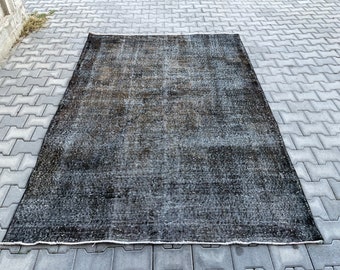 May include: A black and gray vintage rug with a distressed look. The rug has a subtle pattern and is made of a soft, woven material.