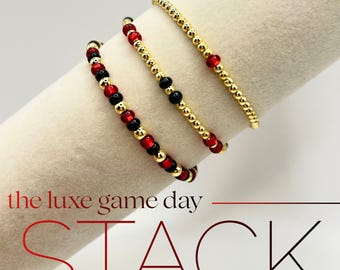 Pulsera roja y negra para el día del juego con cuentas rellenas de oro