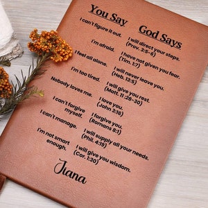 May include: A brown leather journal with the words "You Say" and "God Says" printed on the cover. The journal has a list of phrases and corresponding Bible verses. The name "Jiana" is printed at the bottom of the journal.
