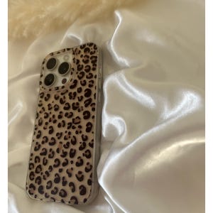 Op de afbeelding: Een transparante telefoonhoes met een bruin en zwart luipaardprintontwerp. De hoes is ontworpen voor een iPhone met een camerabult.