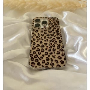 Op de afbeelding: Een transparante telefoonhoes met een luipaardprint. De hoes heeft een verhoogde camerabult en een transparante achterkant.