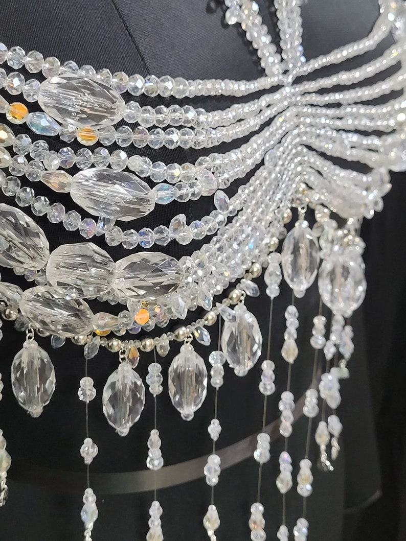 May include: A crystal beaded necklace with a layered design and a cascading fringe of crystal beads.