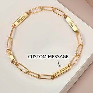 Pode incluir: Pulseira de corrente dourada com três etiquetas de nome personalizadas. As etiquetas dizem "Molly", "Mia" e "Michelle".