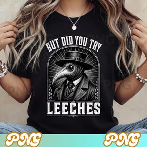 Puede incluir: Camiseta negra con una ilustración en blanco y negro de un médico de la peste con sombrero y máscara. El texto "BUT DID YOU TRY LEECHES" está en blanco. El diseño está centrado.