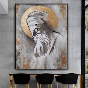 Op de afbeelding: Een ingelijst schilderij met een portret van een man met een lange baard en een aureool. Het kunstwerk gebruikt een palet van grijs, wit en goud, met een textuur achtergrond. Het gezicht van de man is in profiel, de stijl is artistiek.