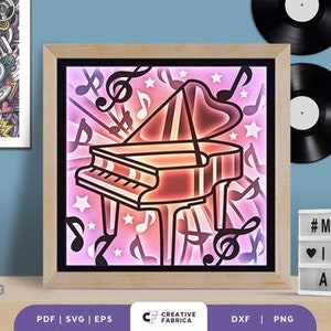 Könnte beinhalten: Eine gerahmte Illustration eines Flügels mit Noten und Sternen in einem rosa und orangenen Farbschema. Der Text "#MUSIC★ ❤IS THE★ ANSWER" befindet sich auf einem weißen Schild unter dem Rahmen.