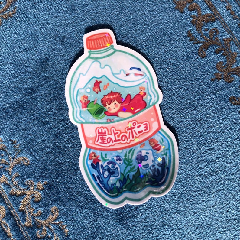 K&ouml;nnte beinhalten: Ein Aufkleber mit einer durchsichtigen Plastikflasche mit einem rosa Etikett, auf dem "星ひとみ" in japanischer Schrift steht. In der Flasche befindet sich eine Comic-Illustration einer Person mit roten Haaren und einem roten Fisch, der in einem blauen und gr&uuml;nen Meer mit Korallen und anderen Fischen schwimmt.