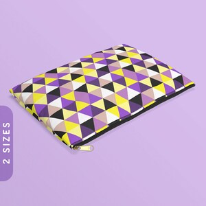 May include: A rectangular zipped pouch featuring a geometric design of yellow, purple, black, white, and tan triangles. The pouch has a black zip and a gold-coloured zip pull. The text "2 SIZES" is on the left side of the image.