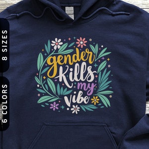 Könnte beinhalten: Marineblauer Kapuzenpullover mit dem Text "gender Kills my vibe" in einem floralen Design. Das Design umfasst gelbe, weiße, rosa und lila Blumen sowie grüne Blätter. Der Pullover hat eine Vordertasche und eine Kapuze mit Kordelzug.