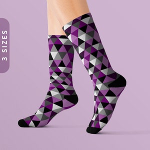 May include: A pair of purple, black, and white geometric patterned socks. The socks are made of a soft, comfortable material and are perfect for everyday wear.