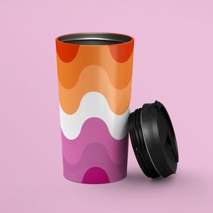 Puede incluir: Una taza de viaje reutilizable con un patrón ondulado colorido en tonos naranja, blanco y morado. La taza tiene una tapa negra con una parte superior roscada.