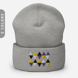 May include: A gray beanie with a folded brim. The brim features an embroidered geometric pattern of yellow, black, white, and purple diamonds. The text "2 COLORS" is on the left side of the image.