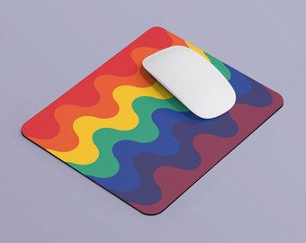 Puede incluir: Una alfombrilla de ratón de color arcoíris con un ratón de ordenador blanco en la parte superior. La alfombrilla de ratón tiene un patrón ondulado.